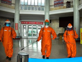 This picture taken on May 17, 2022 and released from North Korea's official Korean Central News Agency on May 18 shows railway station staff disinfecting Pyongyang station premises as a prevention measure against Covid-19.