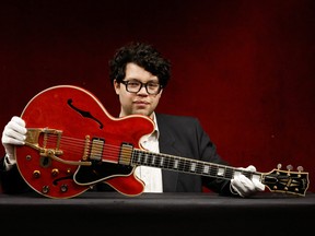 Guitar expert Arthur Perrault holds the Oasis band member Noel Gallagher's Gibson ES-355 guitar, destroyed during an argument with his brother at Paris' Rock en Seine festival in 2009, at a media preview at Hotel Drouot ahead of the auction in Paris, France, May 13, 2022.