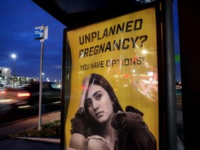 A billboard advertising adoption services targets pregnant women at a bus stop in Oklahoma City, Dec. 7, 2021.