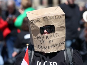 A supporter wears a paper bag at a rally on Parliament Hill during Rolling Thunder Convoy April 30, 2022 in Ottawa.