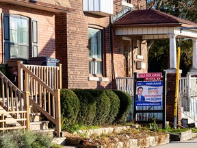 A for sale sign is displayed outside a home in Toronto on Dec. 13, 2021.