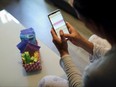 Raquel del Rio, 36, who works in police forces, poses as she observes a period calendar tracker app on her mobile phone at her home in Madrid, Spain, May 16, 2022.