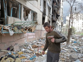 Local resident Viacheslav walks on debris of a residential building damaged by a military strike, as Russia's attack on Ukraine continues, in Sievierodonetsk, Ukraine April 16, 2022.
