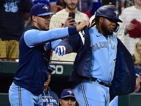 Toronto Blue Jays first baseman Vladimir Guerrero Jr. (right) receives the blue jacket from pitcher Jose Berrios after hitting a solo home run against the St. Louis Cardinals at Busch Stadium on May 24, 2022.
