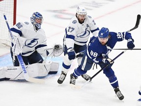 Tampa Bay Lightning goaltender Andrei Vasilevskiy makes a glove save as defenseman Ryan McDonagh battles for position against Toronto Maple Leafs forward William Nylander in Game 7 of the first round of the 2022 Stanley Cup Playoffs at Scotiabank Arena in Toronto.