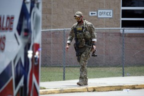 Un officier de la police de l'État du Texas se promène devant la Robb Elementary School à la suite d'une fusillade, le mardi 24 mai 2022, à Uvalde, au Texas.