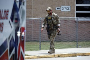 A Texas State Police officer walks outside Robb Elementary School following a shooting, Tuesday, May 24, 2022, in Uvalde, Texas.