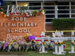 UVALDE, TEXAS - MAY 26: A memorial is seen surrounding the Robb Elementary School sign following the mass shooting at Robb Elementary School on May 26, 2022 in Uvalde, Texas. According to reports, 19 students and 2 adults were killed, with the gunman fatally shot by law enforcement. (Photo by