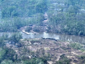 An aerial view of burnt vehicles and the remains of what appears to be a makeshift bridge across the Siverskyi Donets River, eastern Ukraine, in this handout image uploaded on May 12, 2022.