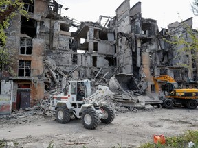 Members of Russia's Emergencies Ministry operate excavators while removing debris of a residential building destroyed during Ukraine-Russia conflict in the southern port city of Mariupol, Ukraine, May 11, 2022.