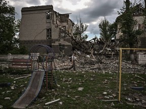 A man walks in front of a destroyed school in the city of Bakhmut, in the eastern Ukranian region of Donbas, Saturday, May 28, 2022.