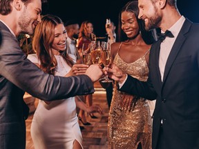 Group of people in formalwear toasting with champagne and smiling