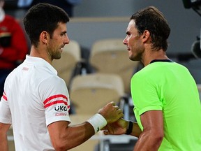 Serbia's Novak Djokovic (L) and Spain's Rafael Nadal shake hands at the end of their men's singles semi-final tennis match on Day 13 of The Roland Garros 2021 French Open tennis tournament in Paris on June 11, 2021.