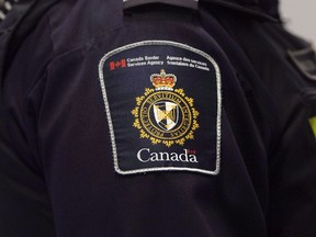 A Canadian Border Services agent stands watch at Pearson International Airport in Toronto, Dec. 8, 2015.