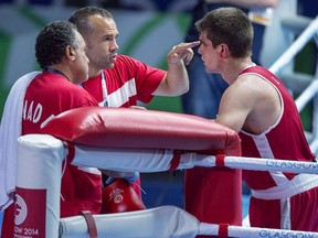 Canada's Brody Blair from New Glasgow, N.S. talks with coaches Daniel Trepanier and Kevin Howard, left, after fighting Abdul Bangura of Sierra Leone in 75 kg boxing action at the Commonwealth Games in Glasgow, Scotland on Saturday, July 26, 2014.