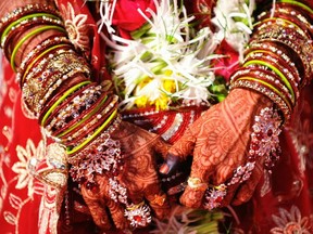 This file photo shows  Indian bride with bangles and henna-decorated hands taking part in a mass marriage ceremony in Mumbai on May 29, 2010.