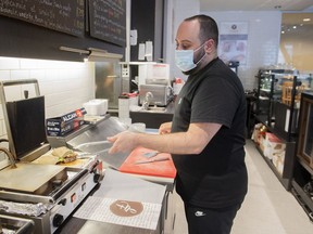 Karam Gebran prepares a sandwich at his Cafe, Les Moulins La Fayette, in Montreal, Jan. 31, 2022.