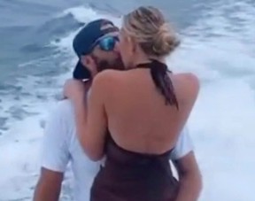 Dustin Johnson getting a kiss from wife Paulina Gretzky while on a boat.
