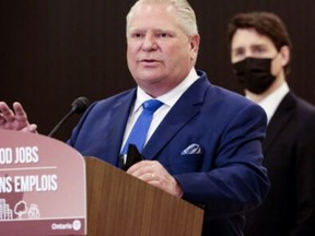 As Prime Minister Justin Trudeau looks on, Ontario Premier Doug Ford speaks at the Stellantis Automotive Research and Development Centre in Windsor on May 2, 2022.