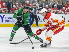 May 7, 2022; Dallas, Texas, USA; Dallas Stars center Roope Hintz (24) and Calgary Flames defenseman Christopher Tanev (8) chase the puck during the third period in game three of the first round of the 2022 Stanley Cup Playoffs at American Airlines Center. Mandatory Credit: Jerome Miron-USA TODAY Sports