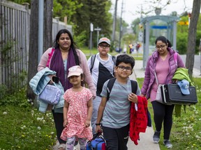 Ryan Islam, 10, (front), Ronin Malik, 11, (back) and their mothers, Rehnuma Naureen (left) and Suman Sandhu, walk home from William G Davis Junior Public School in Scarborough on Friday May 27, 2022. The day before, a 27-year-old man, holding what turned out to be a pellet gun, was shot and by police near the school and died.