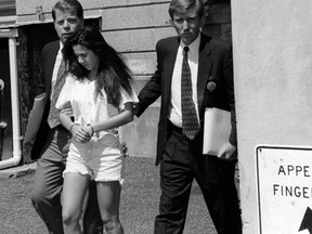Long Island Lolita Amy Fisher does the perp walk with detectives.