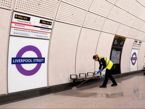 A cleaner works on a platform at Liverpool Street station during a test run of a Transport for London (TfL) Elizabeth Line train between Paddington station and Liverpool Street station and back, in London on May 11, 2022.