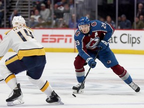 Nathan MacKinnon # 29 of the Colorado Avalanche advances the puck against Mattias Ekholm # 14 of the Nashville Predators in the second period during Game One of the First Round of the 2022 Stanley Cup Playoffs.