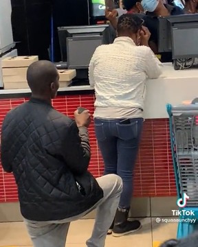 Ein Mann geht während eines Heiratsantrags an seinen Partner in einem geschäftigen McDonald's in Südafrika auf ein Knie.