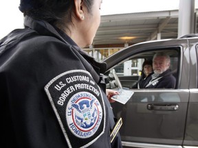 In this  April 9, 2009 photo, U.S. Customs and Border Protection officer Victoria Stephens speaks with a couple using NEXUS identification cards at a border crossing from Canada into the United States at Blaine, Wash.