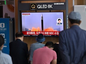 Die Menschen sehen am 25. Mai 2022 an einem Bahnhof in Seoul einen Fernsehbildschirm mit einer Nachrichtensendung mit Dateimaterial eines nordkoreanischen Raketentests, nachdem Nordkorea nach Angaben des südkoreanischen Militärs drei ballistische Raketen auf das Japanische Meer abgefeuert hatte.