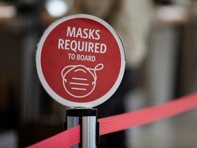 An outdated sign requiring Delta Air Lines passengers to wear a face mask to board a plane are displayed in the domestic terminal of the Hartsfield-Jackson Atlanta International Airport, in Atlanta, April 19, 2022.