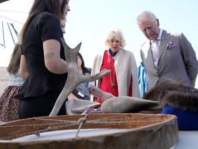 Prince Charles, right, and Camilla, Duchess of Cornwall, second from right, look at a display of traditional hunting tools and clothing after arriving in Yellowknife, Northwest Territories, during part of the Royal Tour of Canada, Thursday, May 19, 2022.