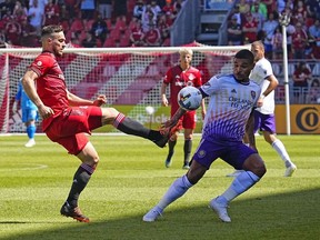 Toronto FC forward Jesus Jimenez kicks the ball as Orlando City SC midfielder Junior Urso defends at BMO Field.