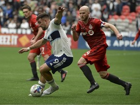 May 8, 2022; Vancouver, British Columbia, CAN; Vancouver Whitecaps forward Lucas Cavallini (9) controls the ball against Toronto FC midfielder Michael Bradley (4) during the second half at BC Place.