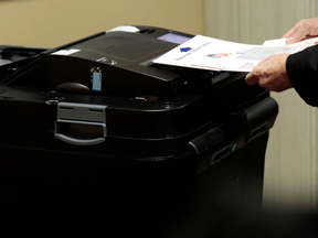 A person places his ballot in a tabulating machine as they vote in midterm election at the St. Paul Lutheran Church in East Lansing, Michigan, U.S. November 6, 2018.