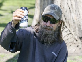 Afghanistan war veteran Nathan Malcolm, who doesn't agree with the City of Toronto hiring private security guards to patrol parks, enjoys a beer in a downtown park on Thursday, May 12, 2022.