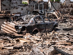 Dieses am 11. Mai 2022 aufgenommene Bild zeigt ein verbranntes Auto und einen Traktor nach dem Beschuss durch russische Streitkräfte in der Stadt Orikhiv in der Nähe von Saporischschja in der Ostukraine.