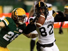 Edmonton Elks' Jordan Hoover (28) tackles Hamilton Tiger-Cats' Steven Dunbar Jr. (82) during first half CFL action at Commonwealth Stadium in Edmonton, on Friday, Oct. 29, 2021.