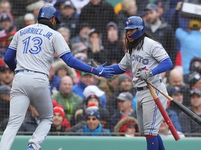 Lourdes Gurriel Jr. #13 of the Toronto Blue Jays celebrates with hitting coach Guillermo Martinez #16 after scoring a run against the Boston Red Sox during the fourth inning of the Red Sox home opening game at Fenway Park on April 09, 2019 in Boston, Massachusetts.