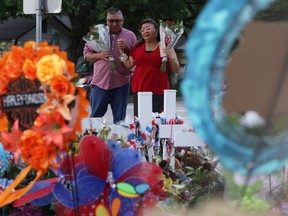 Yvette Reyes and her husband Albert Reyes of San Antonio pay their respects to the shooting victims at a memorial outside Robb Elementary School June 1, 2022 in Uvalde, Texas.