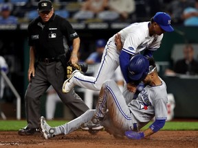 Lourdes Gurriel Jr.  the Toronto Blue Jays collides with pitcher Albert Abreu #69 of the Kansas City Royals while sliding into home plate to score on a wild pitch during the 8th inning of the game at Kauffman Stadium on June 06, 2022 in Kansas City, Missouri.