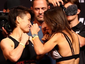 Zhang Weili (L) of China and Joanna Jedrzejczyk of Poland face off ahead of their strawweight bout during the UFC 275 Weigh-in at Singapore Indoor Stadium on June 10, 2022 in Singapore.