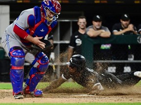 Tim Anderson of the Chicago White Sox slides home to score in the 11th inning against Alejandro Kirk #30 of the Toronto Blue Jays at Guaranteed Rate Field on June 21, 2022 in Chicago, Illinois.