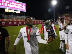 Toronto FC forward Ayo Akinola walks with the Voyageurs Cup after defeating Forge FC at Tim Hortons Field.