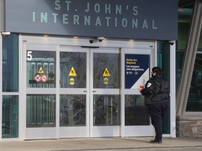 A person stands at the main entrance to the St. John's International Airport terminal on Wednesday, Jan. 19, 2022.