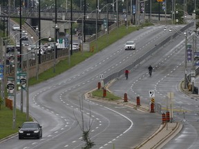 A pair of cyclists come westbound along the the ActiveTO road closure along Lake Shore Blvd W.  (eastbound lanes), between Windermere Ave. and Stadium Rd. on Sunday, Aug. 1, 2021.