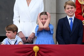 Prinzessin Charlotte hält sich die Ohren zu, während sie mit den Brüdern Prinz Louis und Prinz George steht, um eine besondere Vorbeifahrt vom Balkon des Buckingham Palace nach der Geburtstagsparade der Königin, Trooping the Colour, am 2. Juni 2022 zu sehen. (Foto von DANIEL LEAL/AFP über Getty Images )