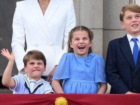 Prince Louis of Cambridge,  Princess Charlotte of Cambridge and Prince George of Cambridge, react as they watch a special flypast from Buckingham Palace balcony following the Queen's Birthday Parade, the Trooping the Colour, as part of Queen Elizabeth II's platinum jubilee celebrations, in London on June 2, 2022.
