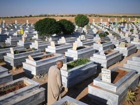 A Syrian man mourns near graves of fighters in a cemetary in the Kurdish town of Kobane in northern Syria, on July 16, 2017.    ges